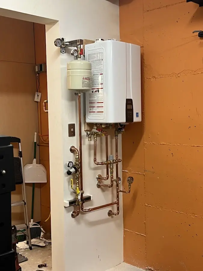 Plumbing technician inspecting water heater connections in Hillside